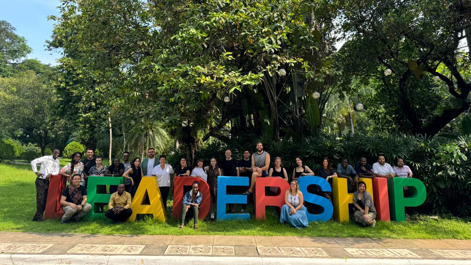 Preview image for the video "Education in Emergencies System Leaders Community" - A diverse group of young adults stands around a 3D multi-colored sign that says Leadership.