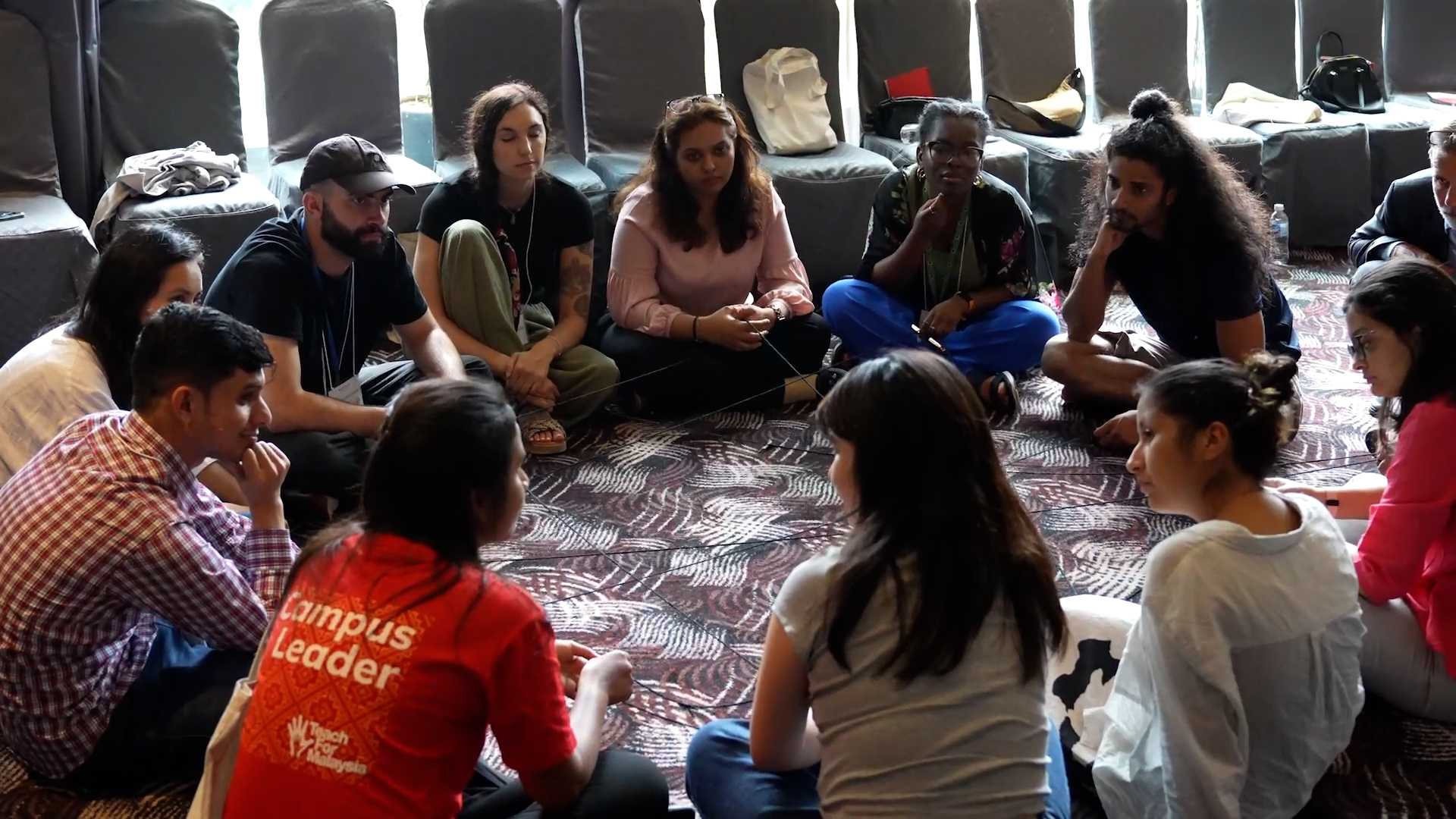 Preview image for the video "Healing, Leadership, and Change: The Impact of the 2024 Leading from Lived Experience Fellowship" - A diverse group of young adults sit in a circle on a carpeted floor.