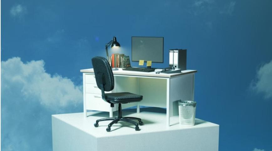 A white desk with a computer screen on it and a black chair in front of it are on a white pillar in a blue cloudy sky