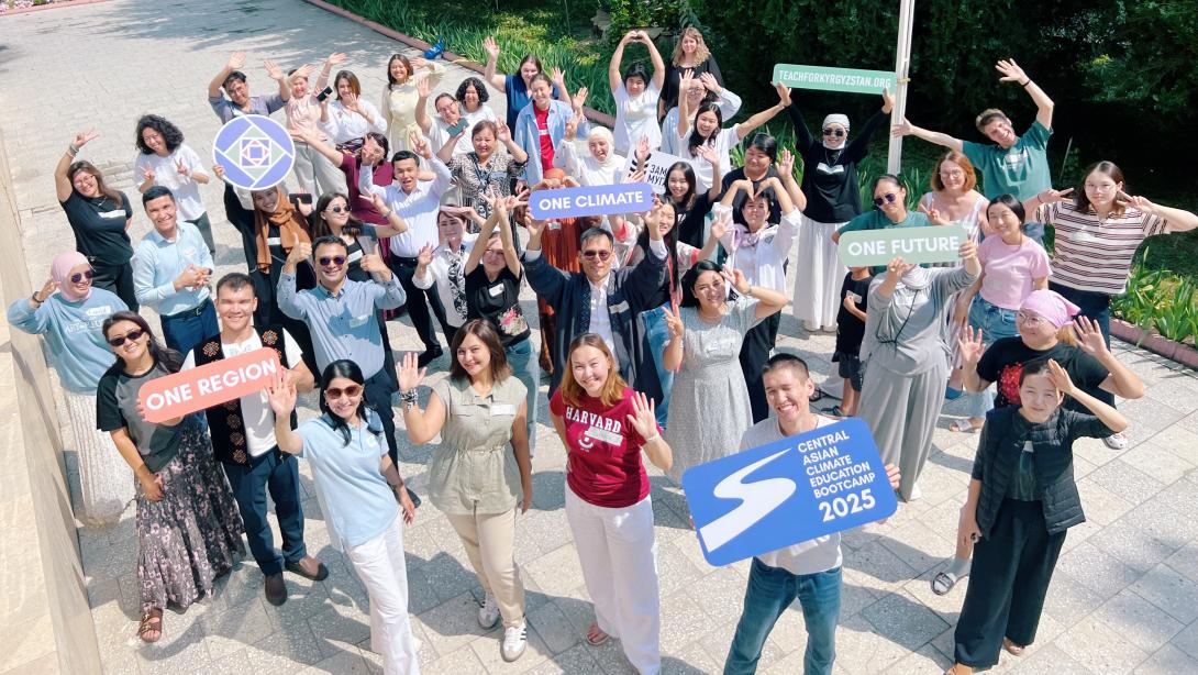 A group of adults stand outside. They are holding up signs that read "One Region," "One Climate," "One Future" and "Central Asian Climate Bootcamp 2025"